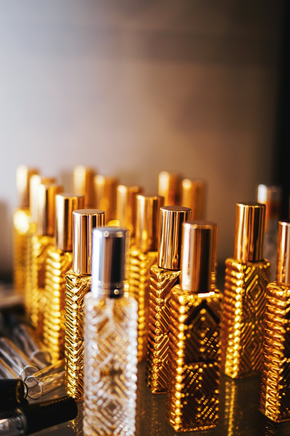 Rows of golden perfume bottles with textured patterns.