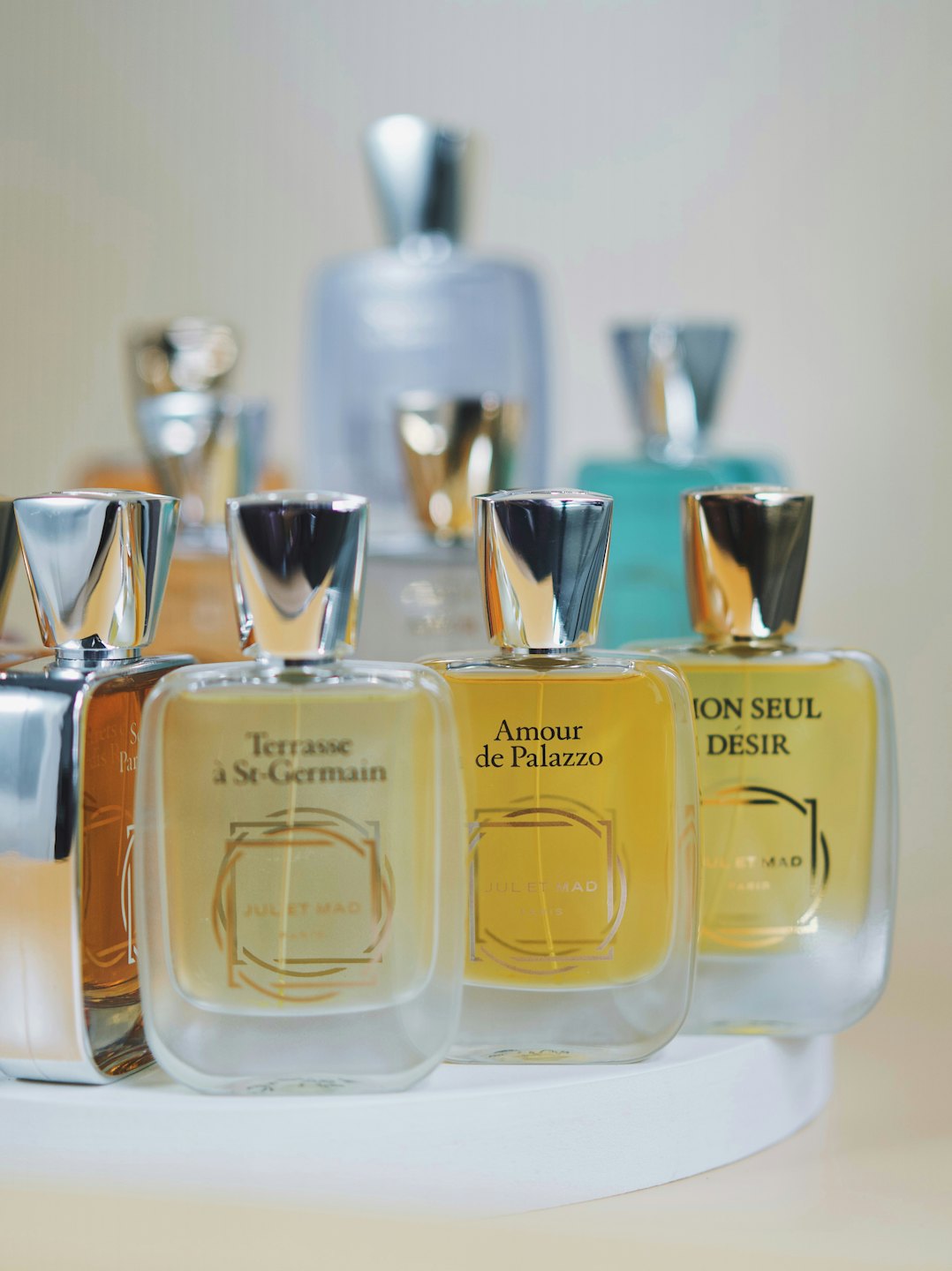Luxury perfume bottles arranged on a white display stand.